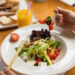 Woman eating beautiful vegetarian salad close up
